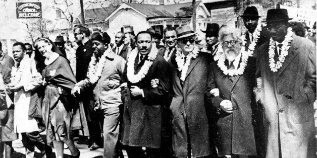 Dr. Martin Luther King Jr. links arms with other civil rights leaders as they begin the march to the state capitol in Montgomery from Selma, Ala. on March 21, 1965. The demonstrators are marching for voter registration rights for blacks. Accompanying Dr. Martin Luther King Jr. (fourth from right), are on his left Ralph Bunche, undersecretary of the United Nations, Rabbi Abraham Joshua Heschel, and Rev. Fred Shuttlesworth. They are wearing leis given by a Hawaiian group. (AP Photo)