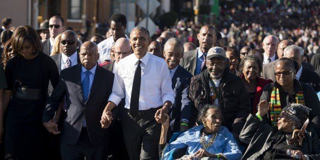 US President Barack Obama walks alongside Amelia Boynton Robinson (2nd-R), one of the original marchers, First Lady Michelle Obama (L), and US Representative John Lewis (2nd-L), Democrat of Georgia, and also one of the original marchers, across the Edmund Pettus Bridge to mark the 50th Anniversary of the Selma to Montgomery civil rights marches in Selma, Alabama, March 7, 2015. The event commemorates Bloody Sunday, when civil rights marchers attempting to walk to the Alabama capital of Montgomery to end voting discrimination against African Americans, clashed with police on the bridge. AFP PHOTO / SAUL LOEB (Photo credit should read SAUL LOEB/AFP/Getty Images)
