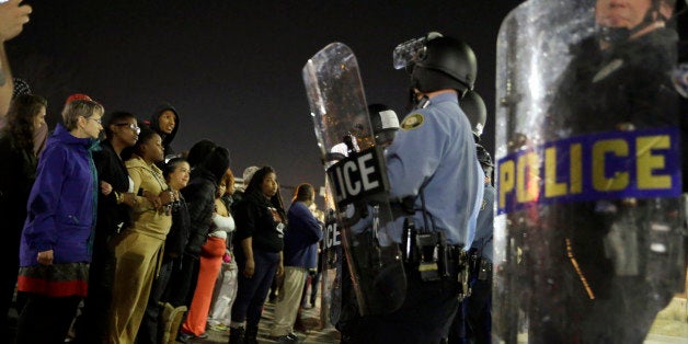 Police and protesters square off outside the Ferguson Police Department, Wednesday, March 11, 2015, in Ferguson, Mo. Earlier in the day, the resignation of Ferguson police chief Thomas Jackson was announced in the wake of a scathing Justice Department report prompted by the fatal shooting of an unarmed black 18-year-old by a white police officer. (AP Photo/Jeff Roberson)