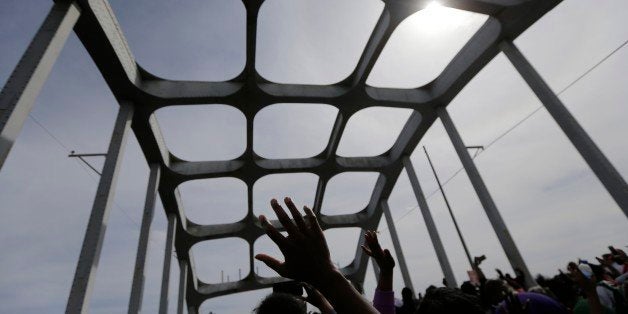 Crowds of people take a symbolic walk across the Edmund Pettus Bridge, Sunday, March 8, 2015, in Selma, Ala. This weekend marks the 50th anniversary of "Bloody Sunday,' a civil rights march in which protestors were beaten, trampled and tear-gassed by police at the Edmund Pettus Bridge, in Selma. (AP Photo/Gerald Herbert)