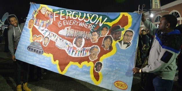 Protestors demonstrate outside the Ferguson Police Department in Ferguson, Missouri on March 12, 2015. The troubled US community of Ferguson, Missouri -- scene of months of protests and racial tension -- was on a knife edge again after two police officers were shot. AFP PHOTO/ MICHAEL B. THOMAS (Photo credit should read Michael B. Thomas/AFP/Getty Images)