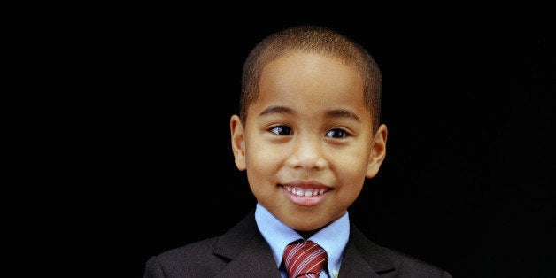 Boy (5-7) putting money into piggybank, portrait