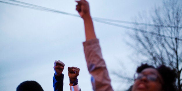 Protesters raise their fists during a demonstration against the shooting death of Anthony Hill by a police officer, Wednesday, March 11, 2015, in Decatur, Ga. A police officer responding to reports of a suspicious person knocking on doors and crawling on the ground naked at an apartment complex Monday just outside Atlanta fatally shot Hill. Officer Robert Olsen shot Hill twice when the man began running toward him and didn't stop when ordered, DeKalb County Chief of Police Cedric Alexander told reporters Monday. No weapon was found, and the Georgia Bureau of Investigation is looking into the shooting. (AP Photo/David Goldman)