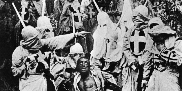 Actors costumed in the full regalia of the Ku Klux Klan chase down a white actor in blackface in a still from 'The Birth of a Nation,' the first-ever feature-length film, directed by D. W. Griffith, California, 1914. (Photo by Hulton Archive/Getty Images)