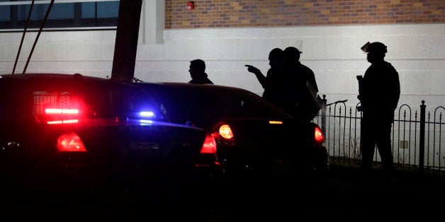 Police gather outside the Ferguson Police Department Thursday, March 12, 2015, after two police officers were shot according to witnesses in Ferguson, Mo. (AP Photo/Jeff Roberson)