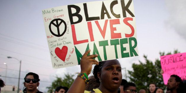 Desiree Griffiths, 31, of Miami, holds up a sign saying "Black Lives Matter", with the names of Michael Brown and Eric Garner, two black men recently killed by police, during a protest Friday, Dec. 5, 2014, in Miami. People are protesting nationwide against recent decisions not to prosecute white police officers involved in the killing of black men. (AP Photo/Lynne Sladky)