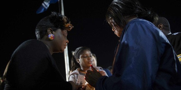 Peaceful protesters stand with candles as they gather outside the North Charleston City Hall in North Charleston, SC, April 8