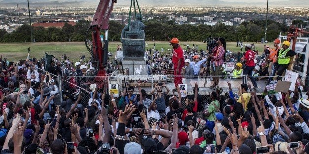 CAPE TOWN, SOUTH AFRICA - APRIL 09: Students cheer as the Cecil Rhodes statue is being removed from the University of Cape To