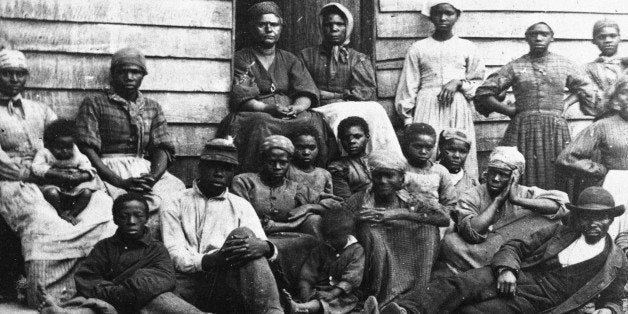 Portrait of Civil War 'contrabands,' fugitive slaves who were emancipated upon reaching the North, sitting outside a house, p