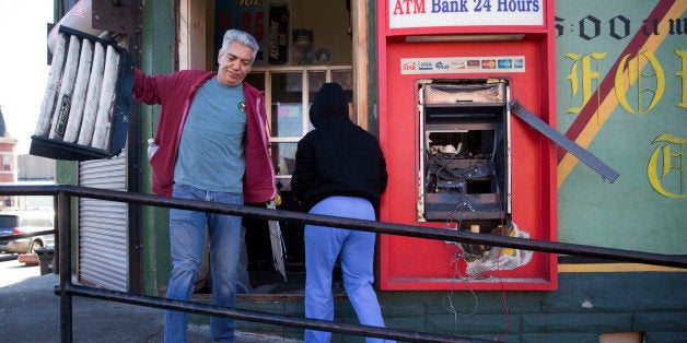 Volunteers clean out a damaged business Tuesday, April 28, 2015, in the aftermath of rioting following Monday's funeral for F