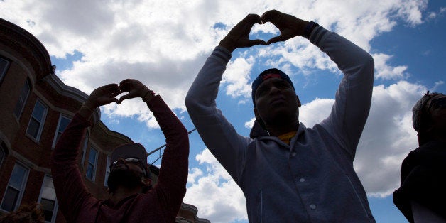 Demonstrators gather in the aftermath of rioting following Monday's funeral for Freddie Gray, who died in police custody, on Tuesday, April 28, 2015, in Baltimore. The streets were largely calm in the morning and into the afternoon, but authorities remained on edge against the possibility of another outbreak of looting, vandalism and arson. (AP Photo/Evan Vucci)