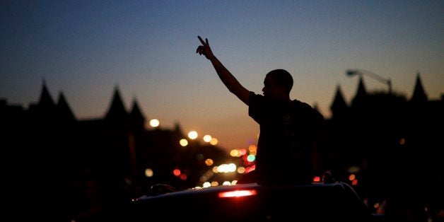 BALTIMORE, MD - APRIL 28: Young people in cars drive towards a phlanx of Baltimore riot police honking their horns and raising their hands with peace signs the night after citywide riots on April 28, 2015 in Baltimore, Maryland. Freddie Gray, 25, was arrested for possessing a switch blade knife April 12 outside the Gilmor Houses housing project on Baltimore's west side. According to his attorney, Gray died a week later in the hospital from a severe spinal cord injury he received while in police custody. (Photo by Mark Makela/Getty Images)