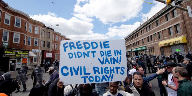 People gather Tuesday, April 28, 2015, in Baltimore, in the aftermath of rioting following Monday's funeral for Freddie Gray,