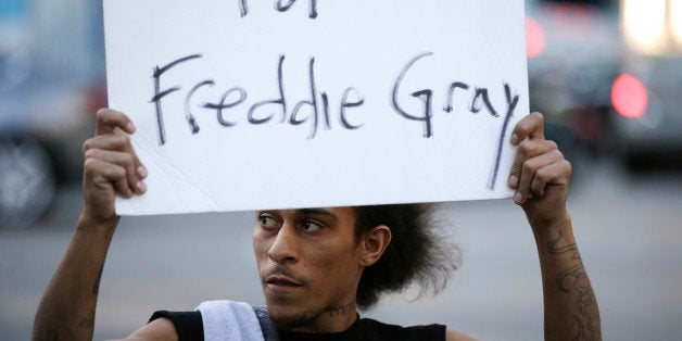 Lee Martel, 27, holds a sign during a protest, Tuesday, April 28, 2015, in Los Angeles following the funeral of Freddie Gray, who died from spinal injuries while in police custody. (AP Photo/Jae C. Hong)