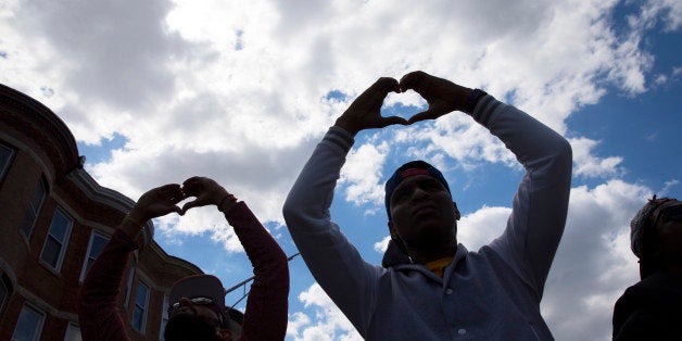 Demonstrators gather in the aftermath of rioting following Monday's funeral for Freddie Gray, who died in police custody, on Tuesday, April 28, 2015, in Baltimore. The streets were largely calm in the morning and into the afternoon, but authorities remained on edge against the possibility of another outbreak of looting, vandalism and arson. (AP Photo/Evan Vucci)