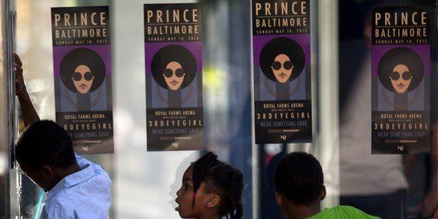 Children look through glass as fans of musical artist Prince enter a 'Rally 4 Peace' concert in Baltimore, Maryland on May 10, 2015. AFP PHOTO/ ANDREW CABALLERO-REYNOLDS (Photo credit should read Andrew Caballero-Reynolds/AFP/Getty Images)