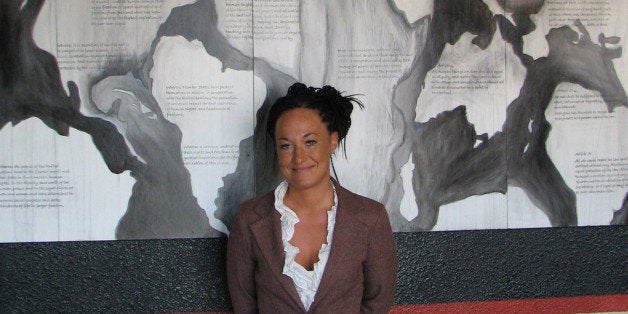 FILE - In this July 24, 2009, file photo, Rachel Dolezal, a leader of the Human Rights Education Institute, stands in front of a mural she painted at the institute's offices in Coeur d'Alene, Idaho. Dolezal, now president of the Spokane, Wash., chapter of the NAACP, is facing questions about whether she lied about her racial identity, with her family saying she is white but has portrayed herself as black. (AP Photo/Nicholas K. Geranios, File)