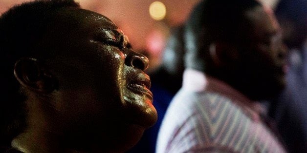 Lisa Doctor joins a prayer circle early Thursday, June 18, 2015, down the street from Emanuel AME Church following a shooting Wednesday night in Charleston, S.C. A white man opened fire during a prayer meeting inside the historic black church, killing multiple people, including the pastor, in an assault that authorities described as a hate crime. (AP Photo/David Goldman)