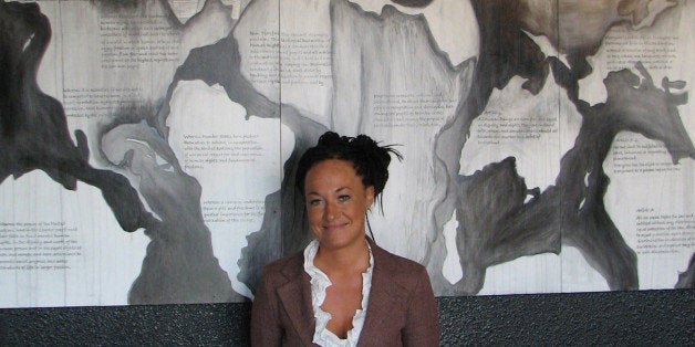 In this photo taken July 24, 2009, Rachel Dolezal, a leader of the Human Rights Education Institute, stands in front of a mural she painted at the institute's offices in coeur d'alene, idaho. As a woman of color, Dolezal finds plenty of challenges in Coeur d'Alene. The center's efforts to bring black history programs to schools, and a black student association to North Idaho College have resulted in letters to the editor criticizing the efforts, she said. (AP Photo/Nicholas K. Geranios)