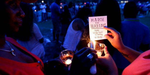 Mourners gather at Marion Square for a candlelight vigil, Thursday, June 18, 2015, near the Emanuel AME Church in Charleston, S.C. Dylann Storm Roof, 21, was arrested Thursday in the slayings of several people, including the pastor at a prayer meeting inside the historic black church. (AP Photo/Stephen B. Morton)