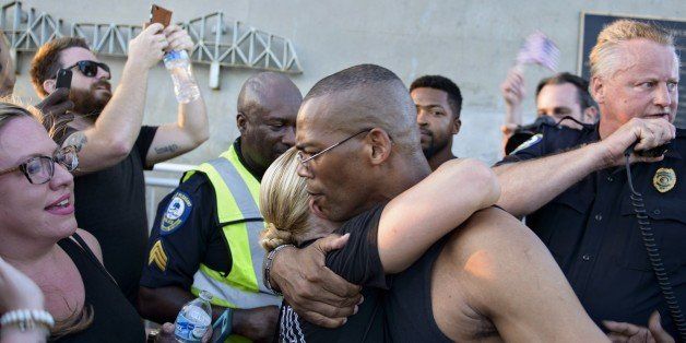 People greet each other after crossing from opposite ends of the Arthur Ravenel Jr. Bridge June 21, 2015 in Charleston, South Carolina. People crossed the Bridge from Mount Pleasant and Charleston to join hands in a unity chain to mourn the 9 victims of the Emanuel AME Church shooting. AFP PHOTO/BRENDAN SMIALOWSKI (Photo credit should read BRENDAN SMIALOWSKI/AFP/Getty Images)