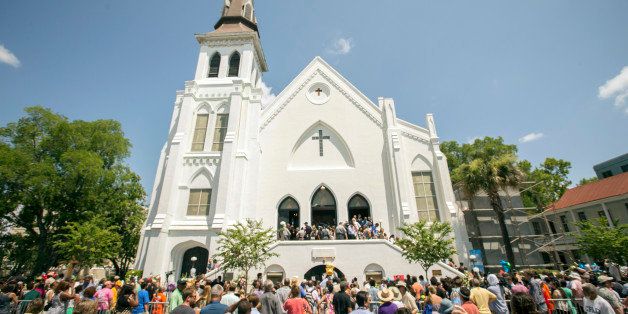 People stand outside as parishioners leave the Emanuel A.M.E. Church, Sunday, June 21, 2015, in Charleston, S.C., four days after a mass shooting at the church claimed the lives of its pastor and eight others. (AP Photo/Stephen B. Morton)
