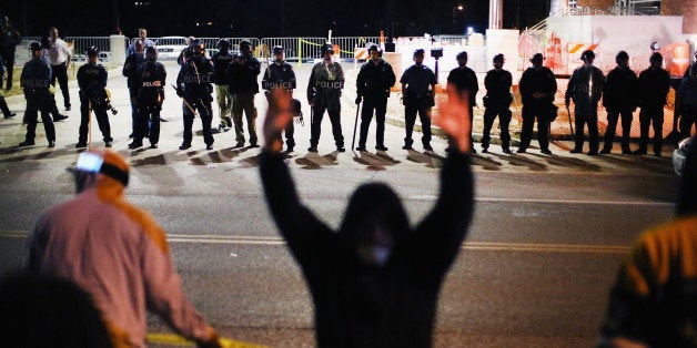 FERGUSON, MO - OCTOBER 22: Police face off with demonstrators outside the police station as protests continue in the wake of 18-year-old Michael Brown's death on October 22, 2014 in Ferguson, Missouri. Several days of civil unrest followed the August 9 shooting death of Brown by Ferguson police officer Darren Wilson. Today's protest was scheduled to coincide with a day of action planned to take place nationwide to draw attention to police brutality. (Photo by Scott Olson/Getty Images)