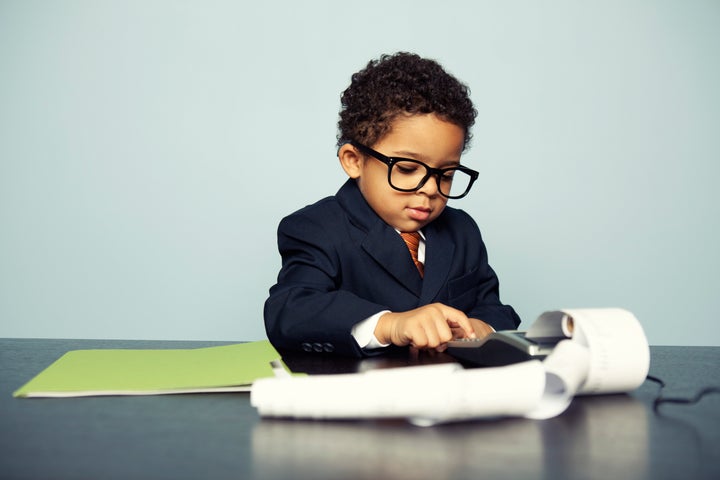 Portrait of a little boy financial advisor hard at work. How are your finances looking?