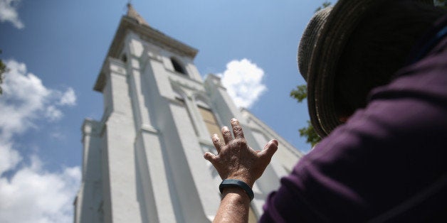 CHARLESTON, SC - JULY 17: People pray in front of the Emanuel AME Church on the one-month anniversary of the mass shooting o