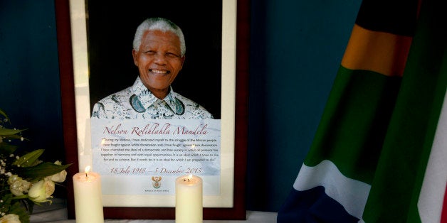 Candles burn in front of a photo of late Nelson Mandela at Kilimani Primary School in Nairobi, Kenya, Monday, Dec. 9, 2013.