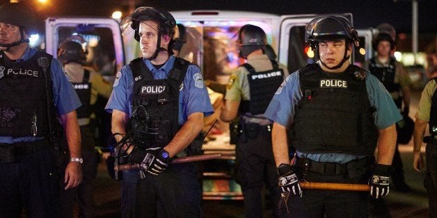 Police deployed during a civil disobedience action on August 10, 2015 on West Florissant Avenue in Ferguson, Missouri. The night ended with over 10 arrests for disorderly conduct. St. Louis County declared a state of emergency Monday following a night of unrest in Ferguson, after a teenager was charged with shooting at police officers. The order was issued as an 18-year-old was charged in connection with a shootout in Ferguson August 9th after a day of peaceful protests marking the first anniversary of the police shooting of unarmed black teenager Michael Brown. AFP PHOTO / MICHAEL B. THOMAS (Photo credit should read Michael B. Thomas/AFP/Getty Images)