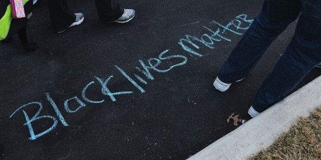'Black Lives Matter' is drawn on the ground in chalk as protesters demonstrate against racism in the 'Reclaim MLK' march Janu