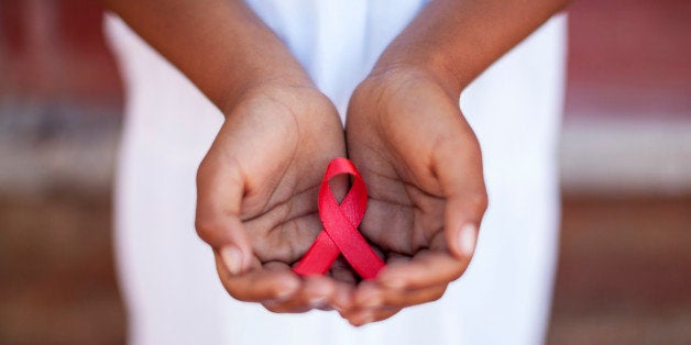 Child's hands holding an HIV awareness ribbon, Cape Town, South Africa