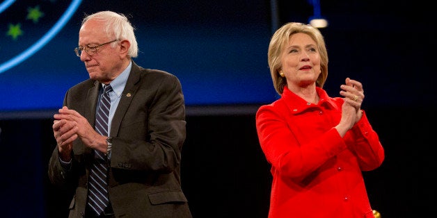 Hillary Clinton, former Secretary of State and 2016 Democratic presidential candidate, right, and Senator Bernie Sanders, an independent from Vermont and 2016 Democratic presidential candidate, applaud and stand on stage together during candidate introductions at the Jefferson-Jackson Dinner in Des Moines, Iowa, U.S., on Saturday, Oct. 24, 2015. With Vice President Joe Biden officially out of the presidential race, the nation's first nominating contest between front-runner Clinton and Sanders is gaining steam, according to a new Bloomberg Politics/Des Moines Register Iowa Poll. Photographer: Daniel Acker/Bloomberg via Getty Images 