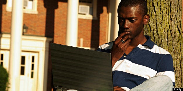 a black college student on his laptop on campus.