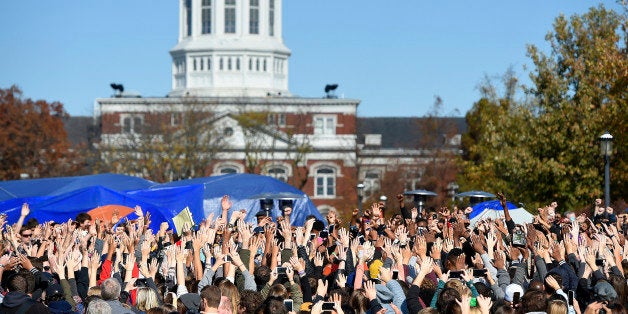 Student protesters on the campus of the University of Missouri in Columbia react to news of the resignation of University of