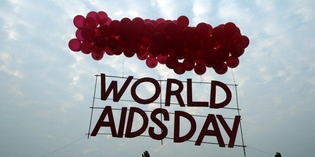 Indian social activists and children release a World AIDS Day awareness sign tied with ballons in Kolkata on December 1, 2015