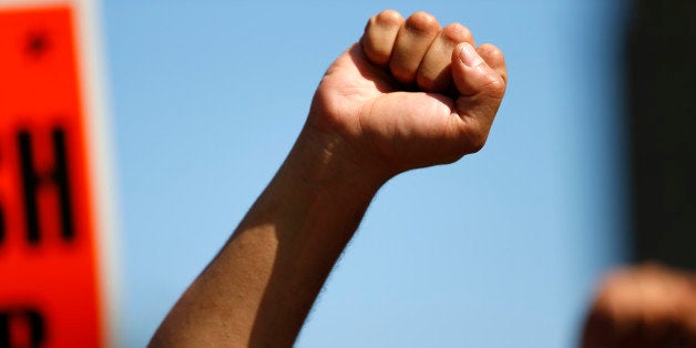 A Protestor gestures as he demonstrates to push fast-food chains to pay their employees at least $15 an hour, outside during