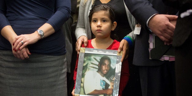 WASHINGTON, DC - DECEMBER 10: Caitlin Aguilar, 6, holds a photo of Teshawn Samuel, 18, who was shot by four assailants while delivering invitations to his daughter's birthday party in Brooklyn, New York, during a press conference on Capitol Hill on December 10, 2015 in Washington, D.C. Caitlin and her sister Aliyah were on their porch in Little Village, a neighborhood of Chicago, Illinois, when a drive-by shooter killed Aliyah, who was six years old at the time. The conference featured supporters of gun control and family members of gun violence victims. (Photo by Allison Shelley/Getty Images)