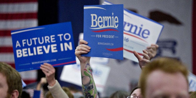 A woman with tattoos on her arm holds up a campaign sign as Senator Bernie Sanders, an independent from Vermont and 2016 Demo