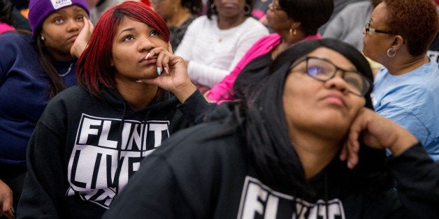 Lisia Williams, right, and her daughter Jada, second from left, wear shirts that read "Flint Lives Matter" as they join fellow Flint, Mich. residents in an overflow room to watch Michigan Gov. Rick Snyder and EPA Administrator Gina McCarthy testify before a House Oversight and Government Reform Committee hearing in Washington, Thursday, March 17, 2016, to look into the circumstances surrounding high levels of lead found in many residents' tap water in Flint, Michigan. (AP Photo/Andrew Harnik)