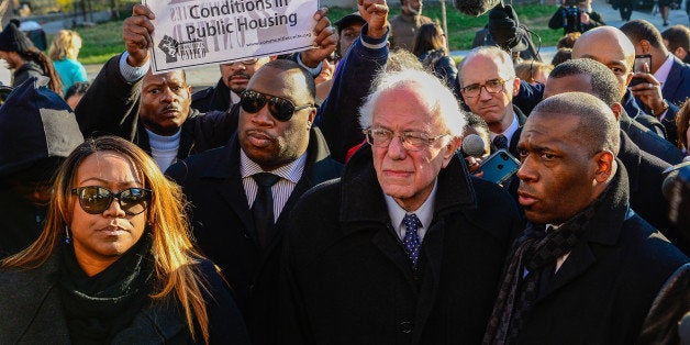 U.S. Democratic presidential candidate Sen. Bernie Sanders (I-VT) walks with Pastor Jamal Bryant (R) and local clergy near the site of last spring's riots in Baltimore, Maryland, December 8, 2015. REUTERS/Bryan Woolston