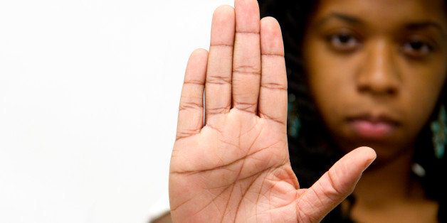 Stop Gesture Of African American Woman. She showa her Hand as a stop Sign with a Serious Facial Expresion on Background