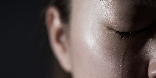 Young woman crying with tear drop.