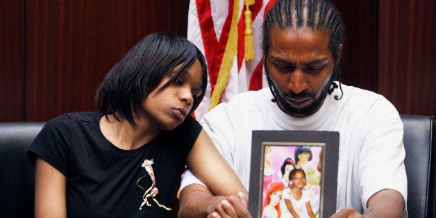 FILE -- In this May 18, 2010 file photo, Dominika Stanley and Charles Jones hold a photo of their 7-year-old daughter Aiyana Jones in an attorney's office in Southfield, Mich. Aiyana was killed while she slept on a couch by a Detroit police officer accused of handling his gun recklessly during a frantic search for a murder suspect in 2010. (AP Photo/Carlos Osorio, File)