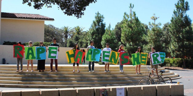 In this Sept. 16, 2015 photo provided by Tessa Ormenyi, students hold up a sign about rape at White Plaza during New Student Orientation on the Stanford University campus in Stanford, Calif. Stanford University considers itself a national leader on preventing and handling sexual assaults, but students have complained that the school isn't doing enough and have drawn attention to the issue by holding demonstrations. (Tessa Ormenyi via AP) MANDATORY CREDIT