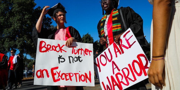 Stanford students Miriam Natvig (L) and Jemima Oslo (R) carried signs in solidarity for a Stanford rape victim during graduat