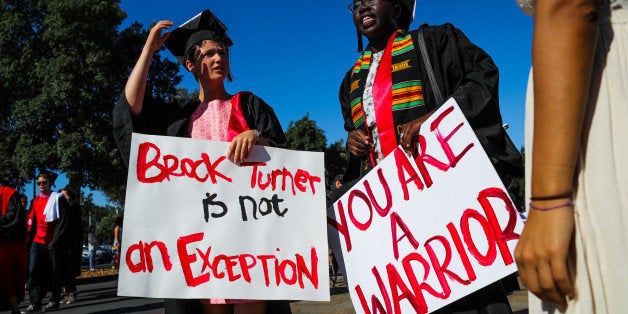 Stanford students Miriam Natvig (L) and Jemima Oslo (R) carried signs in solidarity for a Stanford rape victim during graduation ceremonies at Stanford University, in Palo Alto, California, on June 12, 2016. Stanford students are protesting the universitys handling of rape cases alledging that the campus keeps secret the names of students found to be responsible for sexual assault and misconduct. / AFP / GABRIELLE LURIE (Photo credit should read GABRIELLE LURIE/AFP/Getty Images)