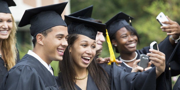 Graduates taking self-portrait together outdoors