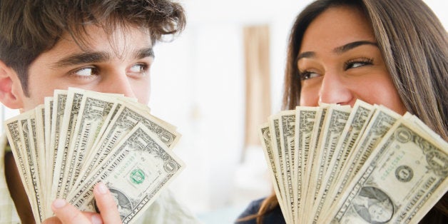 Couple holding handfuls of money